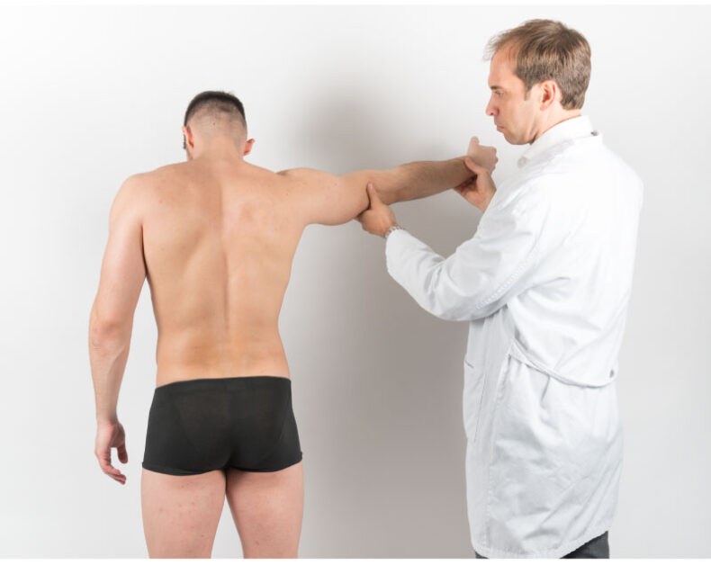 Médico moviendo el brazo de un deportista