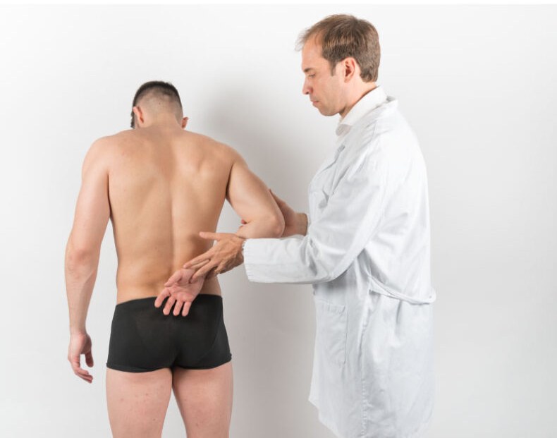Médico valorando la zona lumbar de un deportista